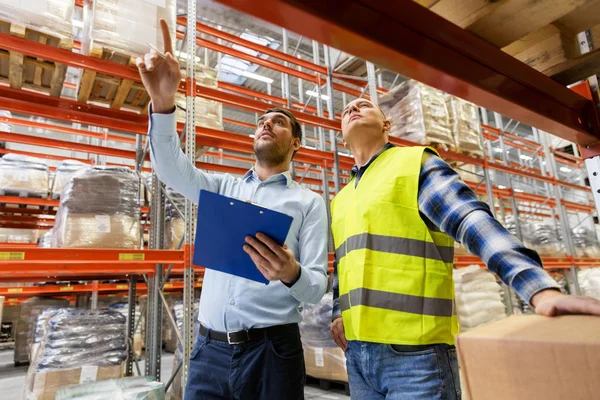 Werknemer en zakenman met Klembord in magazijn — Stockfoto