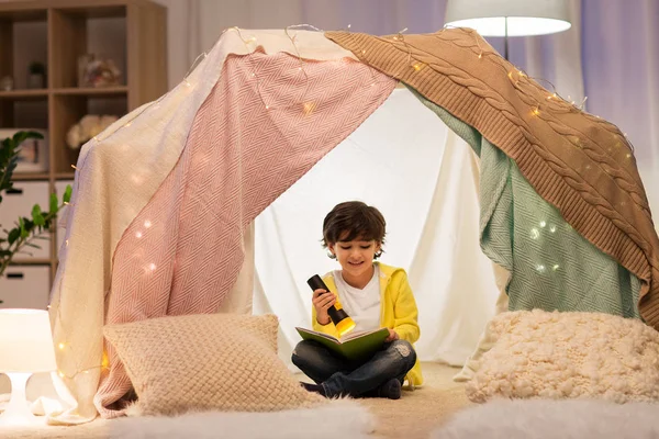 Glücklicher kleiner Junge liest Buch im Kinderzelt zu Hause — Stockfoto