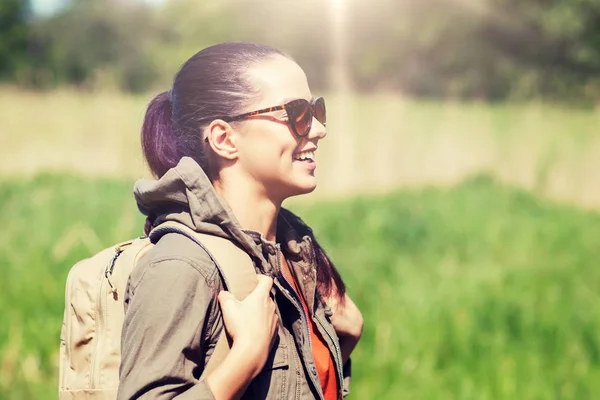 Šťastná mladá žena s batohem pěší venku — Stock fotografie
