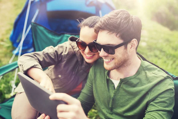Casal feliz com tablet pc na barraca de acampamento — Fotografia de Stock