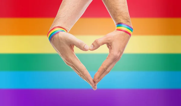 Man handen met gay trots polsbandjes tonen hart — Stockfoto