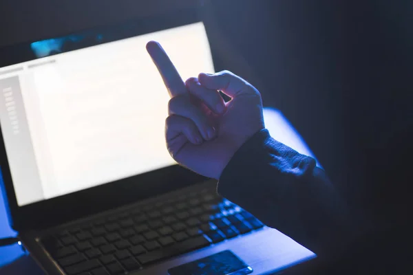 Hacker mostrando dedo medio a la computadora portátil — Foto de Stock