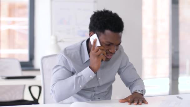 Hombre de negocios llamando en teléfono inteligente en la oficina — Vídeos de Stock