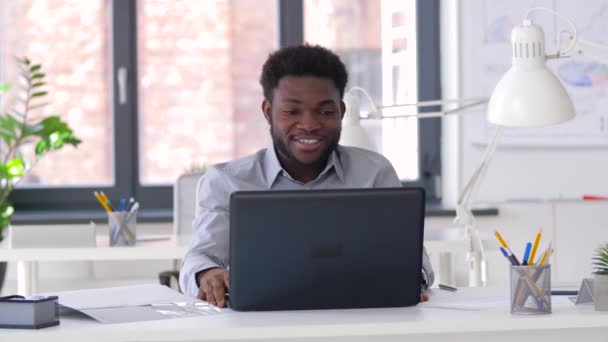 Бізнесмен, який має відео балачку на ноутбуці в офісі — стокове відео