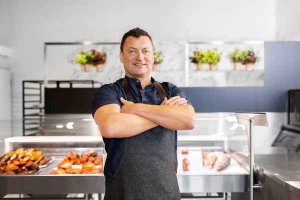 Male seller with seafood at fish shop fridge — Stock Photo, Image