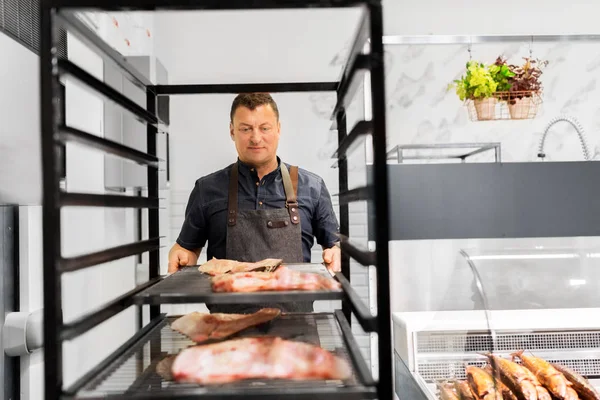 Seller with smoking tray at fish shop — Stock Photo, Image