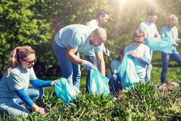 Voluntarios con bolsas de basura limpieza área del parque — Foto de Stock