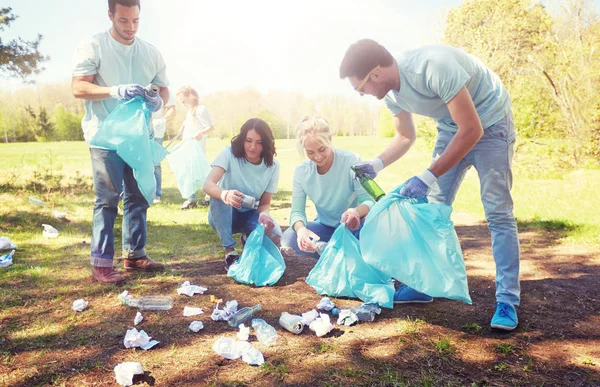 Bénévoles avec sacs à ordures nettoyage de la zone du parc — Photo