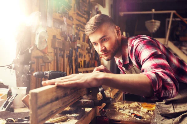 Tischler arbeitet in Werkstatt mit Holzplanke — Stockfoto