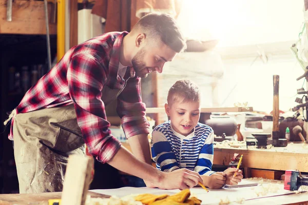 Glücklicher Vater und Sohn mit Blaupause in der Werkstatt — Stockfoto