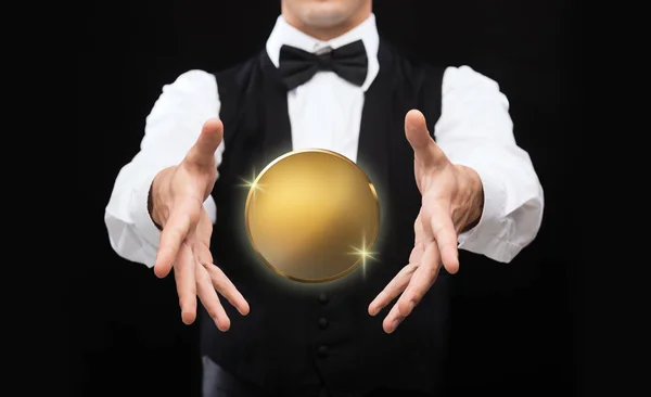 Close up of magician with golden coin over black — Stock Photo, Image