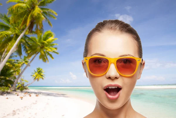 Счастливая женщина или девочка-подросток в солнцезащитных очках на пляже — стоковое фото
