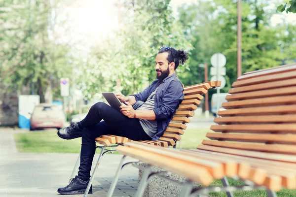 Hombre con la tableta de la PC sentado en la ciudad banco de la calle — Foto de Stock