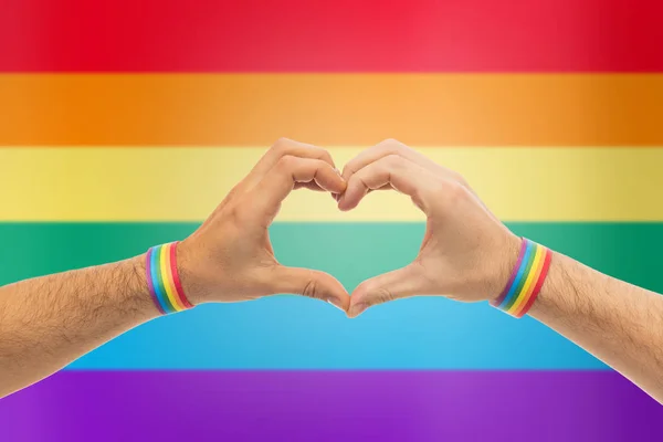 Manliga händer med gay stolthet armband visar hjärta — Stockfoto