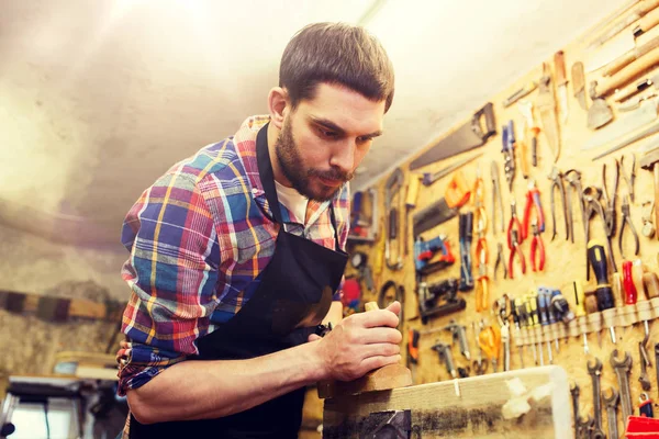 Carpintero trabajando con plano y madera en taller — Foto de Stock