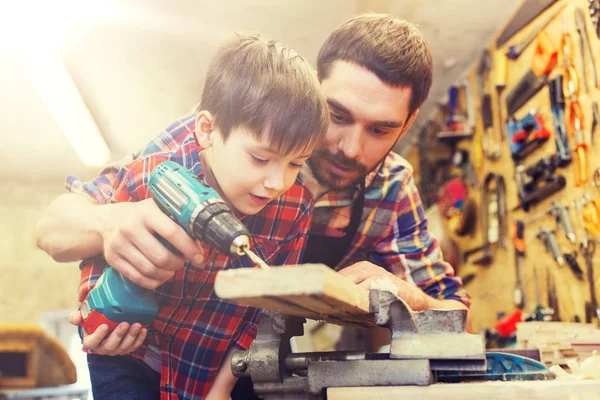 Pai e filho com broca trabalhando na oficina — Fotografia de Stock