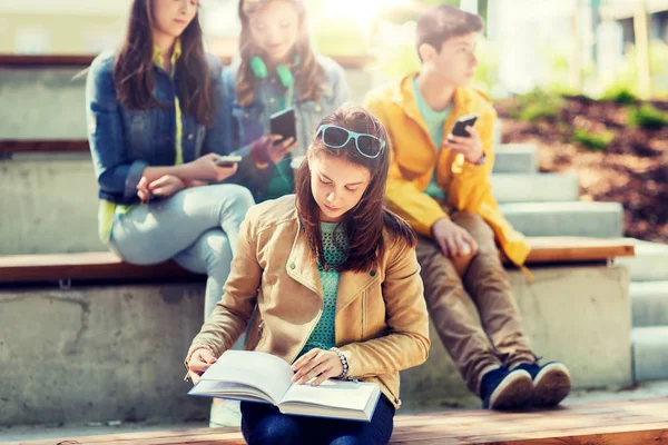 Estudante do ensino médio menina leitura livro ao ar livre — Fotografia de Stock