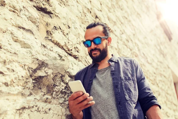 Mann schreibt SMS auf Smartphone an Steinmauer — Stockfoto
