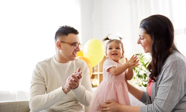 Niña feliz y los padres en la fiesta de cumpleaños en casa —  Fotos de Stock