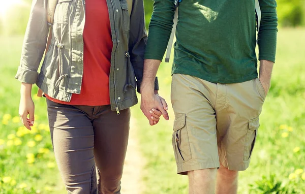 Primer plano de pareja con mochilas cogidas de la mano — Foto de Stock