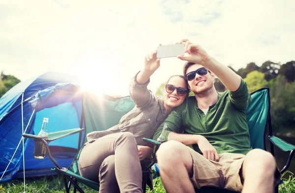 Casal de viajantes tirando selfie por smartphone Imagens De Bancos De Imagens