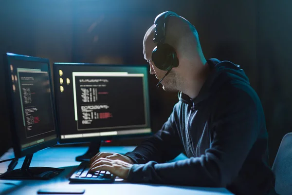 Hacker com codificação no computador portátil no quarto escuro — Fotografia de Stock