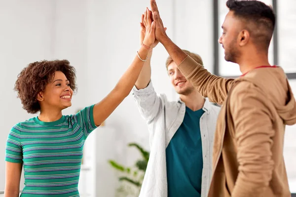 Lyckliga kreativa team att göra high five på kontor — Stockfoto