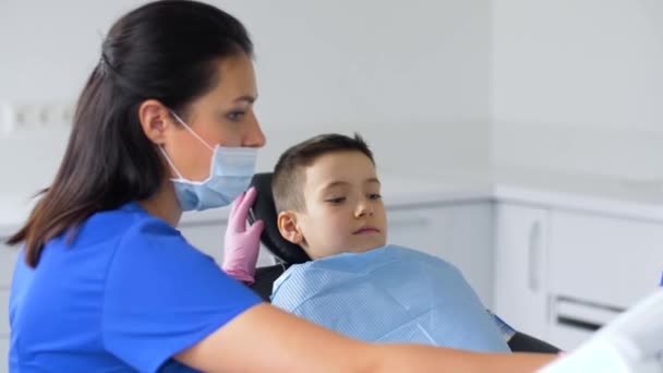 Vrouwelijk tandarts met kid patiënt op tandheelkundige kliniek — Stockvideo