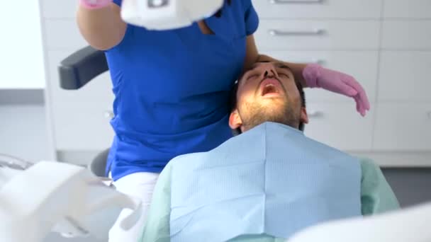 Dentista che controlla i denti del paziente presso la clinica dentistica — Video Stock