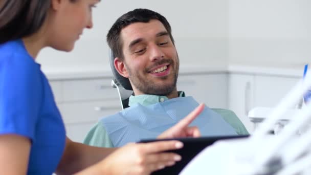 Стоматолог и пациент обсуждают лечение зубов — стоковое видео