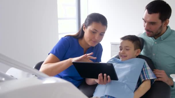 Dentista mostrando tablet pc para paciente na clínica — Vídeo de Stock