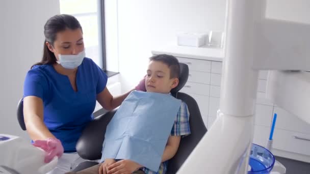 Женщина-дантист с ребенком в стоматологической клинике — стоковое видео