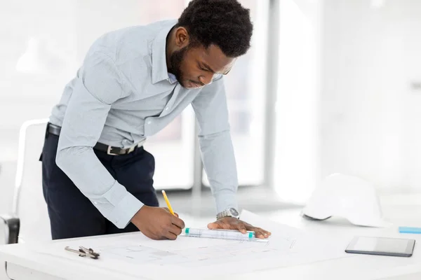 African architect with blueprint at office — Stock Photo, Image