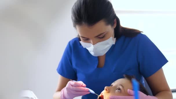 Female dentist with kid patient at dental clinic — Stock Video