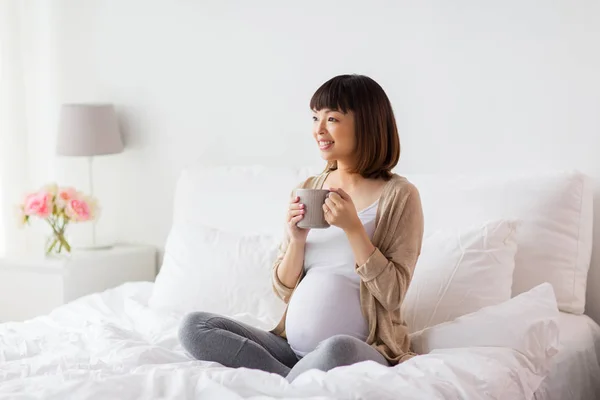 Felice donna incinta con tazza di tè a casa — Foto Stock