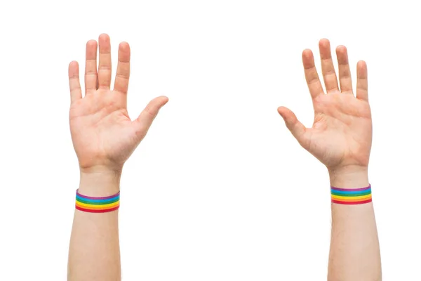 Manos con gay orgullo arco iris pulseras — Foto de Stock