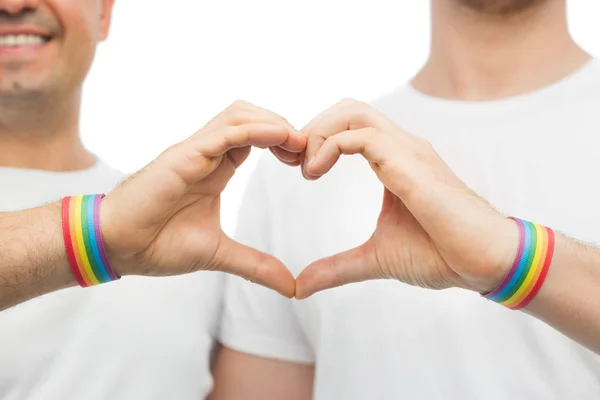 Gay coppia con arcobaleno braccialetti e mano cuore — Foto Stock