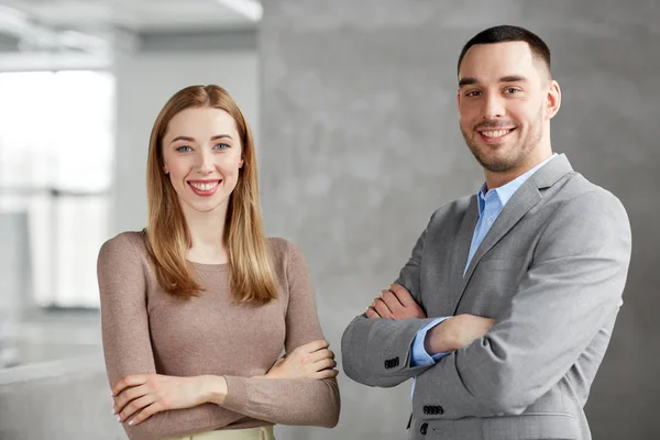 Sonriente mujer de negocios y hombre de negocios en la oficina — Foto de Stock