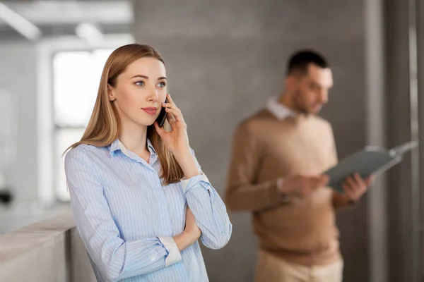 Mujer de negocios llamando en el teléfono inteligente en la oficina — Foto de Stock