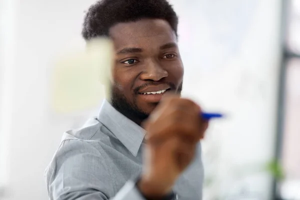 Empresario escribiendo en tablero de cristal en la oficina — Foto de Stock