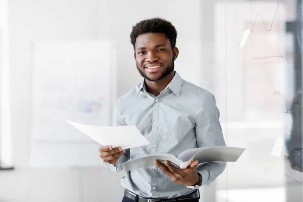 Hombre de negocios afroamericano con carpeta en la oficina —  Fotos de Stock