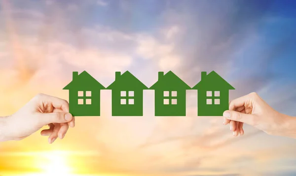Man and woman hands with many green paper houses — Stock Photo, Image