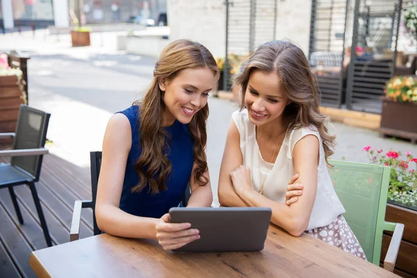 Mujeres jóvenes felices con la PC tableta en la cafetería al aire libre —  Fotos de Stock