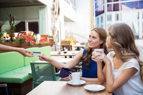 Young women paying for coffee at street cafe — Stock Photo, Image