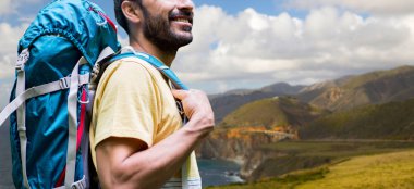 close up of man with backpack on big sur coast clipart