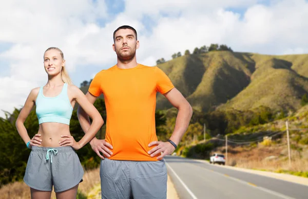 Glückliches Paar beim Sport über große Hügel — Stockfoto