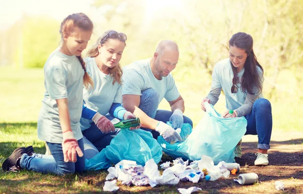 Voluntarios con bolsas de basura limpieza área del parque — Foto de Stock