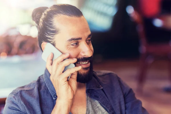 Hombre feliz llamando en el teléfono inteligente en el bar o pub — Foto de Stock