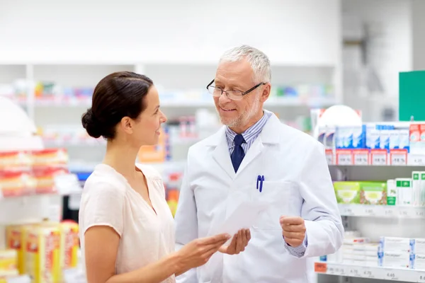 Donna e farmacista con prescrizione medica in farmacia — Foto Stock