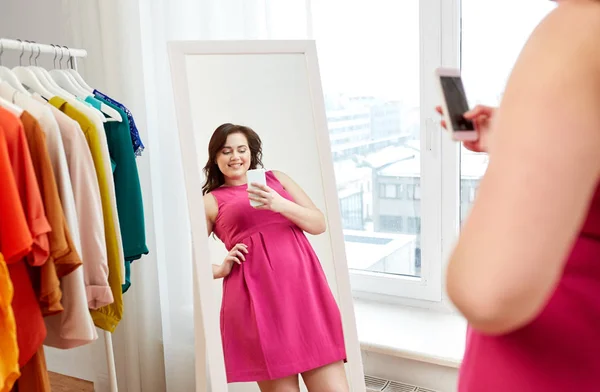 Plus size kvinde tager på spejl selfie hjemme - Stock-foto
